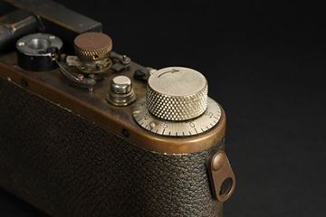 Picture of Oskar Barnack experimental camera (c.1930s), with built-in rangefinder and slow speeds, an unfinished top plate and a missing rangefinder-housing. It has a set of strap lugs totally different from other Leica models. An original Leitz photograph from this era shows Barnack sitting at his desk having this specific camera on the table for testing work. Ex-Leitz Museum sticker M732